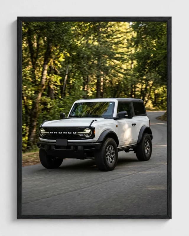 White Ford Bronco transformed into a framed forest road automotive portrait