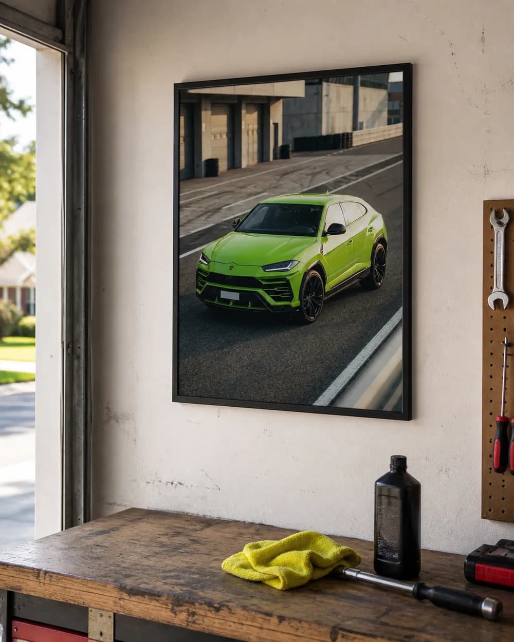 Sample phone photo of a framed green car portrait hanging above a garage workbench